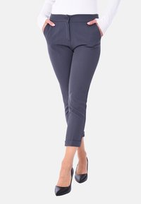 Pantaloni a sigaretta blu navy con una texture liscia, tasche frontali e orlo arrotolato. Presentano una chiusura a bottone e passanti per la cintura.