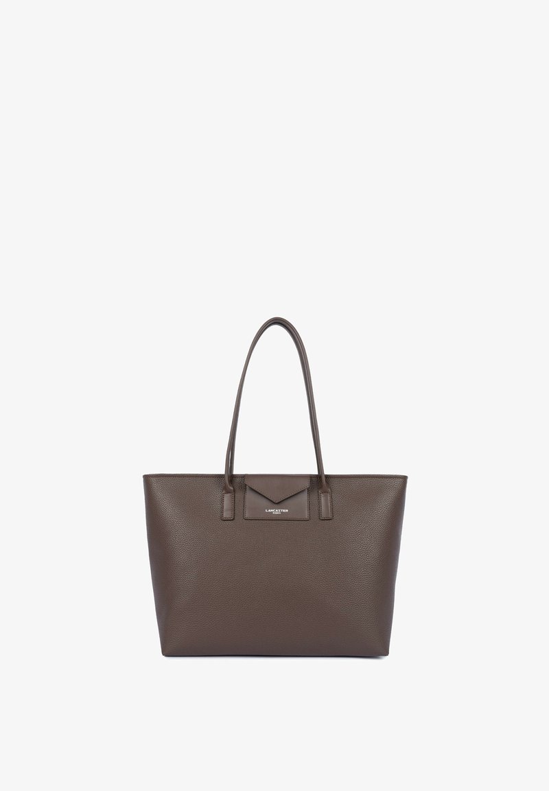 Grand sac cabas en cuir marron avec deux poignées et une petite poche avant, debout sur un fond blanc.