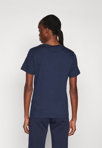 Navyblauwe katoenen t-shirt met korte mouwen, klassieke ronde halslijn en een ontspannen pasvorm. Soepele textuur en eenvoudig ontwerp zonder versieringen.