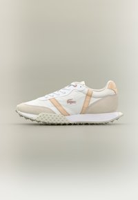 Valged ja beežid madalad tennisetossud, millel on tekstureeritud tald, nöörid ees ning beežid küljeribad neutraalsel taustal.