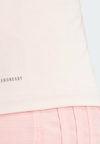 Light pink athletic shirt with a textured fabric. Features a rounded hem and "AEROREADY" text along the bottom.