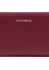 Pochette zip in pelle testurizzata color bordeaux con logo dorato "COCCINELLE" centrato vicino al bordo superiore.