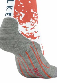 Graue und weiße Socke mit roten Akzenten und einem strukturierten Design. Enthält ein Logo und ein diagonales Streifenmuster im Fersenbereich.