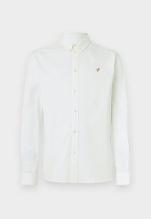 Camicia bianca a maniche lunghe in tessuto di cotone, con colletto button-down e un piccolo emblema arancione sul petto.