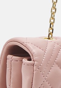 Quilted pink leather handbag with a gold chain strap. Features a structured shape and visible stitching accents, highlighting its texture.