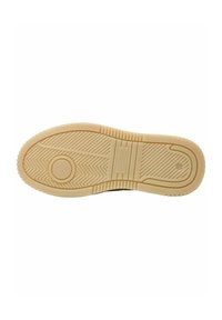 Suola della scarpa in gomma testurizzata di un color beige chiaro, con una scanalatura circolare e un motivo a spina di pesce, progettata per aderenza e trazione.