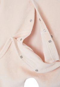 Weiches pinkes Babybekleidungsstück mit teilweise geöffneten Druckknöpfen, das den glatten Innenstoff und die Nähte zeigt.