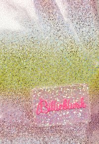 Glitrende stof med en gradient fra pink til gul, med et klart logoemblem med pink tekst "Billieblush" nederst.