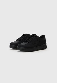 Black athletic shoes featuring a smooth synthetic upper, rounded toe, thick textured sole, and lace-up design with subtle branding accents.