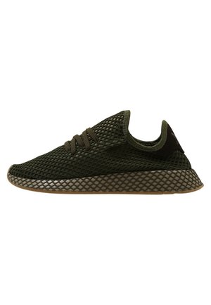 Mørkegrøn mesh-sneaker med tekstureret sål og matchende grønne snørebånd, vist fra sideprofil på hvid baggrund.