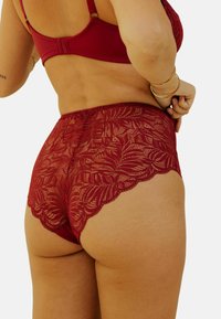 Culotte en dentelle bordeaux avec motif floral et bords festonnés, dotée d'une texture douce et d'une taille en satin lisse pour le confort.