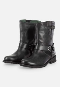 Botines de cuero negro hasta el tobillo con un tacón bajo, que presentan una correa lateral y detalle de hebilla, textura suave y punta redondeada. Forro interior verde.