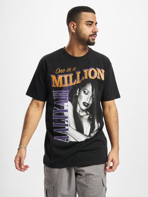 Black cotton t-shirt featuring a graphic print of a woman with bold text reading "One in a Million" in orange and purple. Short sleeves.