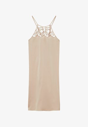 Beżowa sukienka na ramiączkach z cienkimi podwójnymi paskami i kwiatową koronką na wysokości biustu na jednolitym białym tle.