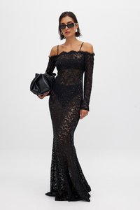 Must mustristiga must lace kleit, millel on pikad varrukad ja õlgadelt avatud kaelus. Istuv siluett, laienev ääreosa, koos musta käekotiga.