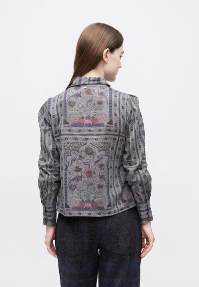 Γκρι μπλούζα με διακοσμητικά λουλουδένια μοτίβα, μακριά μανίκια, δομημένους ώμους και εφαρμοστή γραμμή. Η πλάτη διαθέτει στρογγυλό γιακά.