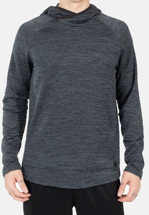 Mann trägt einen dunkelgrauen, langärmligen, kapuzengesäumten Pullover mit dezent strukturiertem Muster und kleinem schwarzem Logo nahe dem Saum.