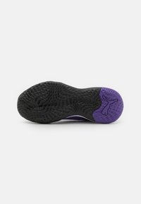Schwarze und lila Sport-Schuhsohle mit einer strukturierten schwarzen Gummifl�äche und einer soliden lila Ferse mit eingeprägtem Logo.