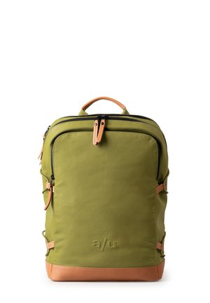 Olivgrüner Rucksack mit glatter Textur, schwarzen Reißverschlüssen, sandfarbenen Lederakzenten und einem auffälligen Logo an der Basis. Verfügt über seitliche Riemen.