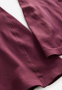 Bordo rebrasti materijal s teksturiranom površinom; ima prilagođeni dizajn i glatke šavove duž rubova za čist završetak.