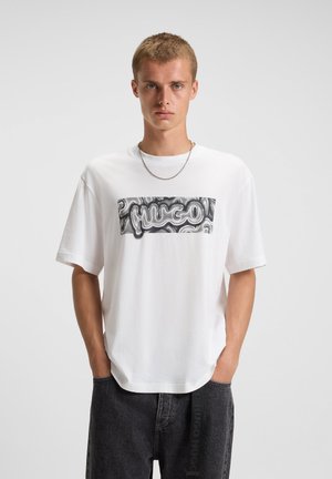Weißes Baumwoll-T-Shirt mit einem horizontalen schwarzen und silbernen Logo-Graphic. Das Shirt hat kurze Ärmel und einen lässigen Schnitt.
