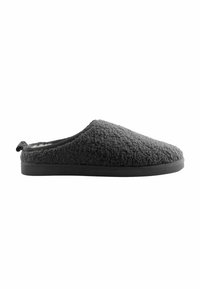 Pantofole grigie slip-on con un esterno morbido e peloso e suola nera piatta, progettate per il comfort interno e una facile indossabilità.
