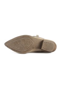 Beige suede shoe sole with a pointed toe, textured grip patterns, and a smooth finish. Features stitching along the edges and subtle branding.