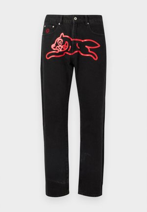 Černé džíny z denimu s velkým červeným motivem skákající kočky na levém stehně. Standardní pětikapsový design s kovovými doplňky.