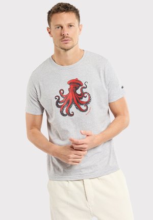T-shirt gris à manches courtes avec un grand graphique de pieuvre rouge et des accents noirs. Le tissu semble doux, avec un col rond et une coupe décontractée.