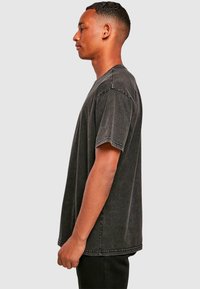 Grå oversized T-shirt i blød bomuld. Løs pasform med kortærmer, rund halsudskæring og synlige sømme. Tekstureret, vasket finish.