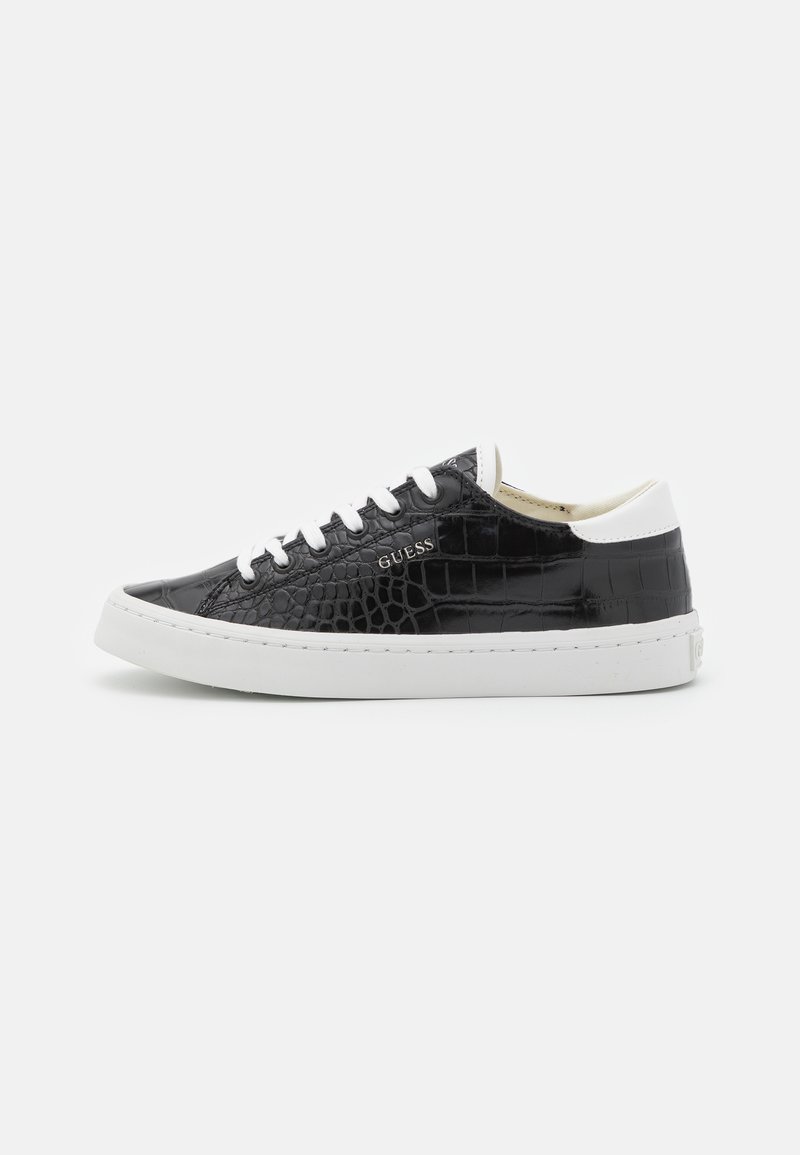 Sneaker in pelle sintetica nera lucida con motivo coccodrillo in rilievo; suola in gomma bianca, lacci e accentuazione del tallone; marchiato "Guess" di lato.