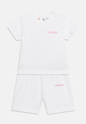 Tenue blanche à manches courtes pour tout-petit avec short assorti, tous deux avec petits logos Off-White roses sur la poitrine et la jambe gauche.
