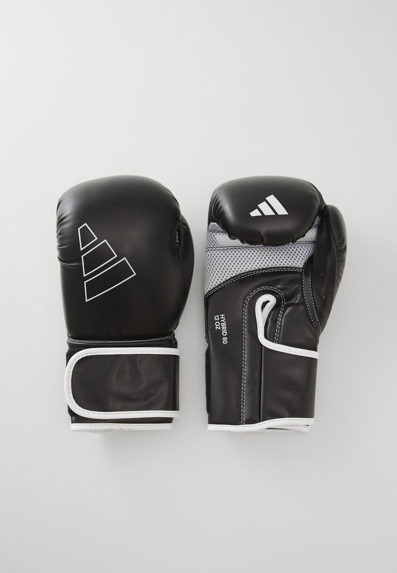 Luvas de boxe pretas com acentos brancos, feitas de couro sintético. Apresentam uma área em rede na parte de trás, tiras resistentes no pulso e um logótipo ousado.
