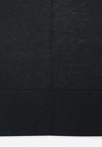 Schwarzer Strickstoff mit glatter Textur, der am unteren Rand gerippte Details und eine subtile tonale Variation aufweist.