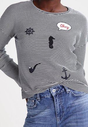 Camicia a maniche lunghe a righe bianche e nere con applicazioni a tema nautico: cavalluccio marino, ancora, pipa e nuvoletta con la scritta "Ahoy" in rosso.