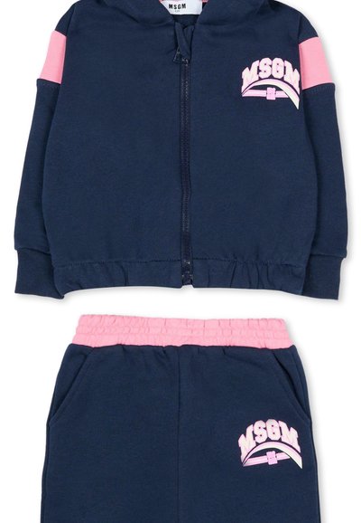 Marineblauwe zip-up hoodie met roze accenten en logo op de borst; gecombineerd met marineblauwe sweatpants met een roze elastische tailleband en zijzakken.