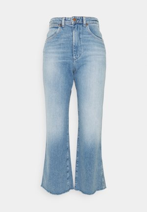 Jeans bleu clair taille haute avec une légère évasement en bas et des ourlets effilochés, avec poches avant et fermeture par bouton.