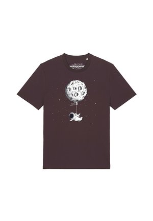 T-shirt marron foncé avec un visuel représentant un astronaute flottant dans l’espace, tenant une ficelle attachée à un ballon en forme de lune cratérisée.