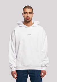 White hooded sweatshirt featuring a front pocket and small black logo on the chest. The fabric appears soft with a relaxed fit.