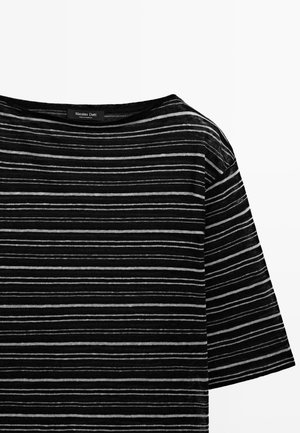 Czarny top z krótkim rękawem, cienkie poziome białe paski i szeroki dekolt, z widoczną metką Massimo Dutti na kołnierzu.