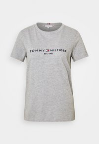 Šedé bavlněné tričko s kulatým výstřihem. Na hrudi je logo "TOMMY HILFIGER EST. 1985" v námořnické a červené barvě. Krátké rukávy, volný střih.