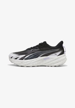 Chaussure de course Puma noire et blanche avec semelle épaisse mouchetée, fermeture à lacets à l'avant et logo sur le côté, montrée en profil gauche sur fond blanc.
