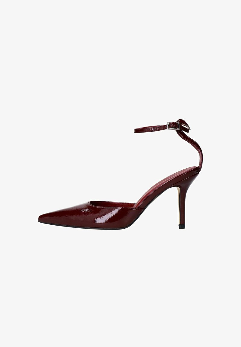 Escarpin bordeaux à talon haut avec un bout pointu, finition en vernis brillant, bride de cheville avec boucle et talon aiguille élancé.