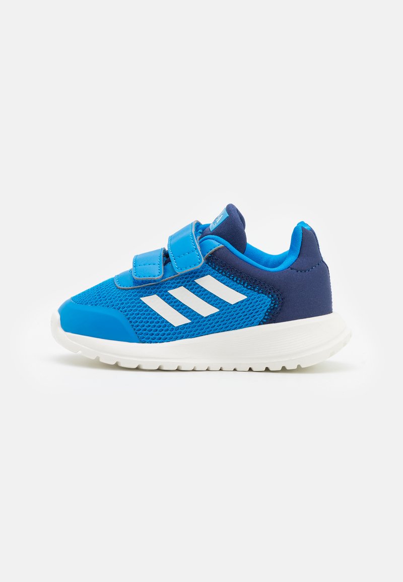Niebieskie buty sportowe z siateczkową cholewką, granatowymi akcentami i zapięciem na rzepy. Białe oznaczenia w postaci trzech pasków po boku, lekkie podeszwy.