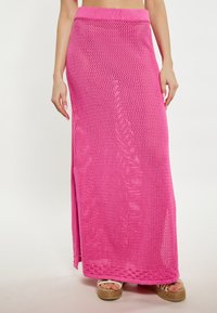 Fustă maxi tricotată roz, cu un design texturat �și țesătură deschisă, având un slit lateral și un talie lată. Asortată cu espadrile cu platformă.