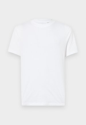 Weißes Baumwoll-T-Shirt mit Rundhalsausschnitt und kurzen Ärmeln. Mit einem kleinen, eingeprägten Logo auf der linken Brust. Glatte Textur.