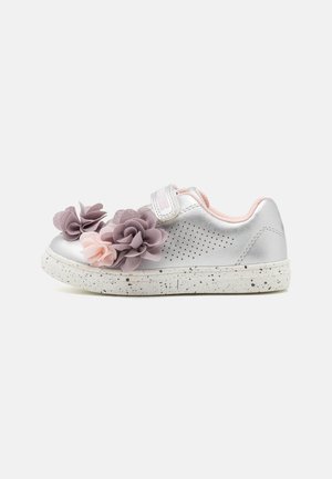 Sneaker argentato con accenti floreali in viola e rosa. Caratterizzato da una cintura in velcro, design perforato e suola bianca screziata.