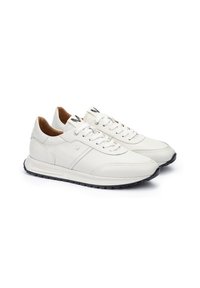 Zapatillas de cuero blancas con detalles en marrón, puntera redondeada, diseño con cordones, suela de goma negra contrastante y sutilezas en la costura.