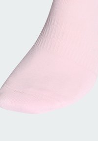 Svetlo roza bombažna nogavica z rebrasto teksturo, zaobljenim prstom in ojačanim šivom na konici, zasnovana za udobje in prileganje.