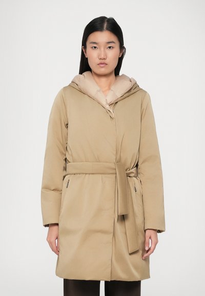 Piumino beige con cintura regolabile, grande cappuccio e texture liscia. Presenta due tasche laterali e una chiusura frontale. Adatto per il freddo.